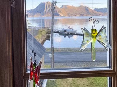 Utsmykning i vinduet og utsikten til hav og fjell..